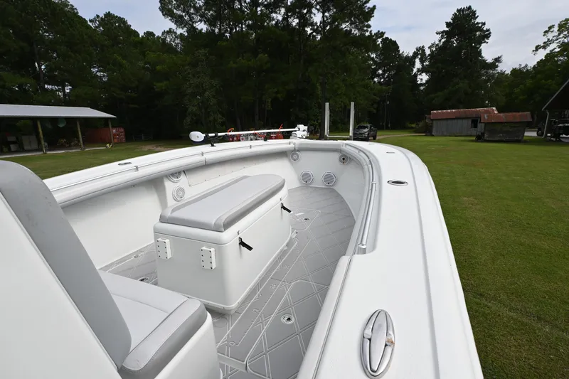 Slide: The Image of 2017 Yellowfin 36 boat interior with seating, set on a grassy area with trees in the background. - 14