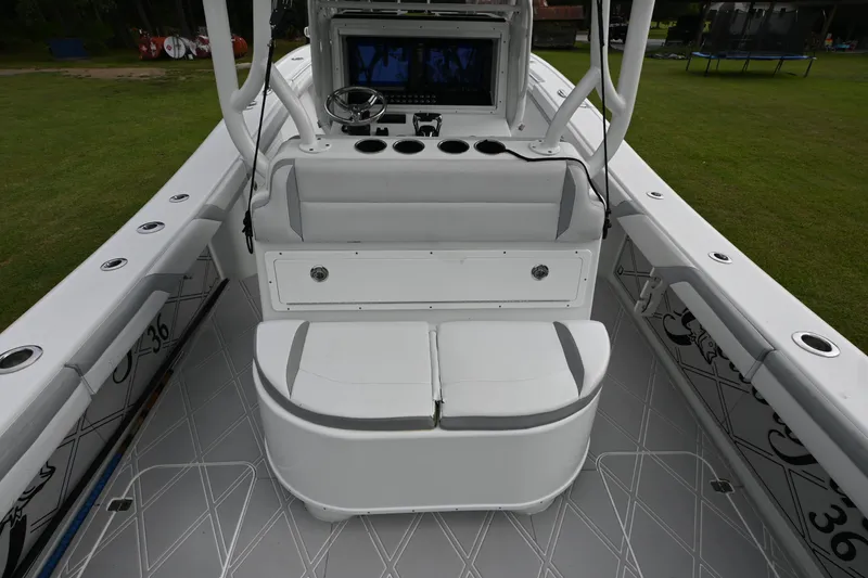 Slide: The Image of 2017 Yellowfin 36 boat interior with seating and control panel, docked on grass. - 21