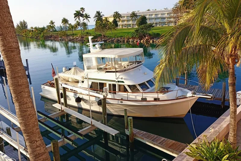 Slide: The Image of 1999 Ocean Alexander 486/510 Classico yacht docked in a tropical marina setting. - 0