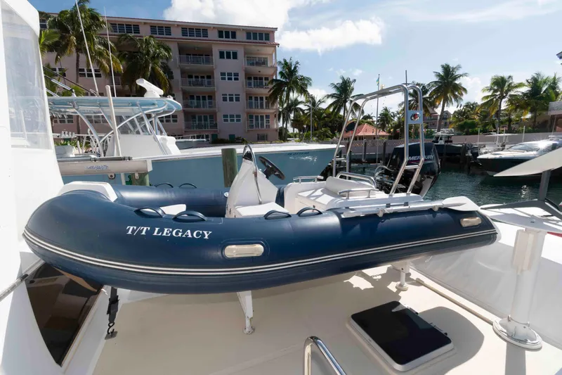 Slide: The Image of 1999 Ocean Alexander 486/510 Classico yacht with inflatable tender, docked near palm trees. - 13