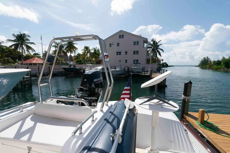Slide: The Image of 1999 Ocean Alexander 486/510 Classico yacht docked near waterfront property, palm trees, and clear skies. - 14