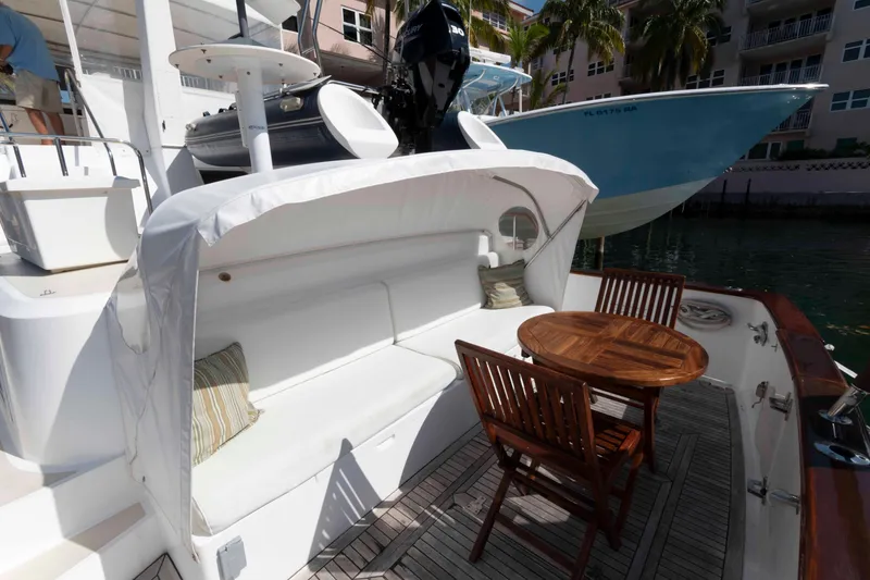 Slide: The Image of 1999 Ocean Alexander 486/510 Classico yacht with cozy outdoor seating and wooden table. - 18