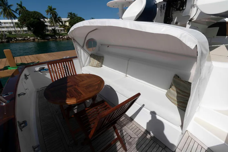 Slide: The Image of Outdoor seating area on 1999 Ocean Alexander 486/510 Classico yacht with wooden table and cushioned bench. - 20