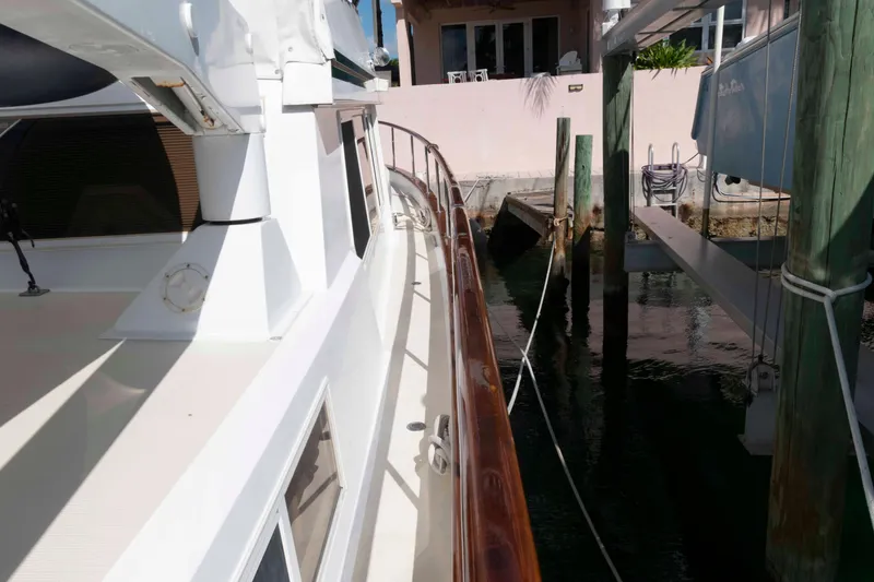 Slide: The Image of 1999 Ocean Alexander 486/510 Classico yacht docked, showcasing sleek design and polished wood railing. - 22
