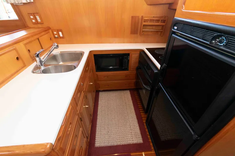 Slide: The Image of 1999 Ocean Alexander 486/510 Classico yacht kitchen with sink, microwave, and stove. - 32