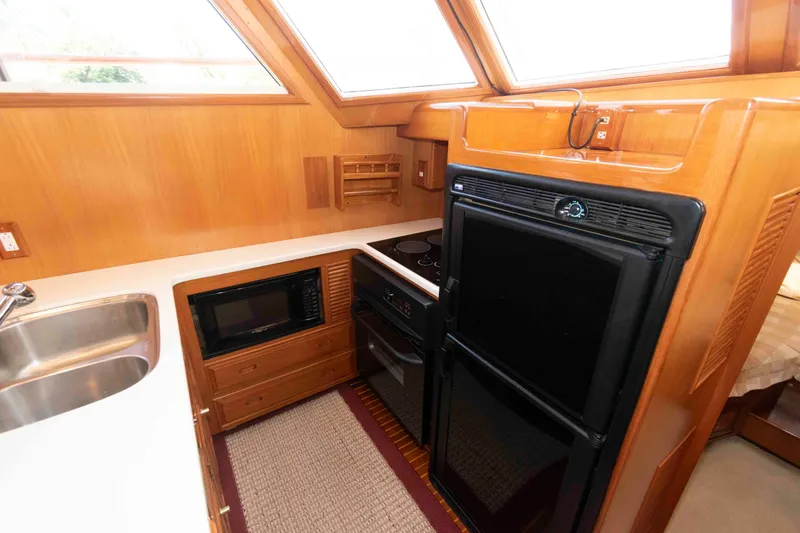 Slide: The Image of 1999 Ocean Alexander 486/510 Classico yacht kitchen with modern appliances and wood finish. - 34