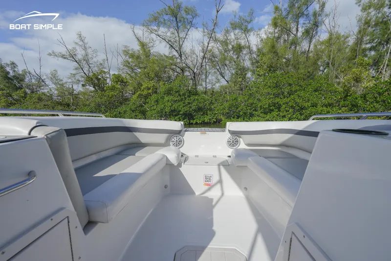 Slide: The Image of 2023 Starcraft SVX 191 OB boat interior with white seating and lush greenery background. - 5