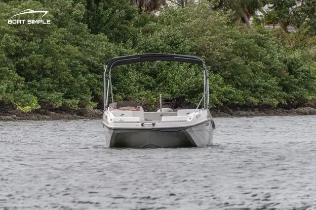 Slide: The Image of 2023 Starcraft SVX 171 OB boat on water, surrounded by lush greenery. - 2