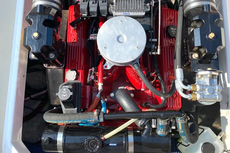 Slide: The Image of Engine of a 2003 Surf-Hunter 25 boat, featuring red components and black fittings. - 12