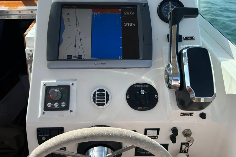 Slide: The Image of Boat dashboard with Garmin navigation, throttle controls, and switches on a 2003 Surf-Hunter 25. - 5