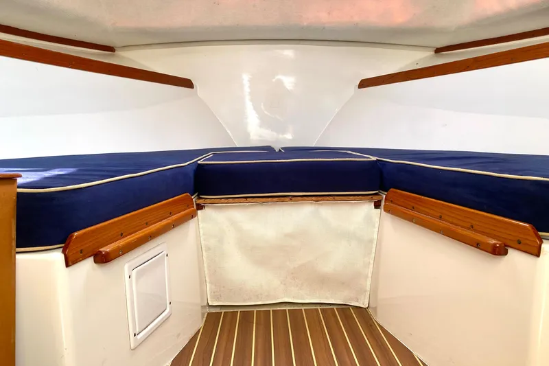 Slide: The Image of Interior cabin of a 2003 Surf-Hunter 25 boat with blue cushions and wooden accents. - 7