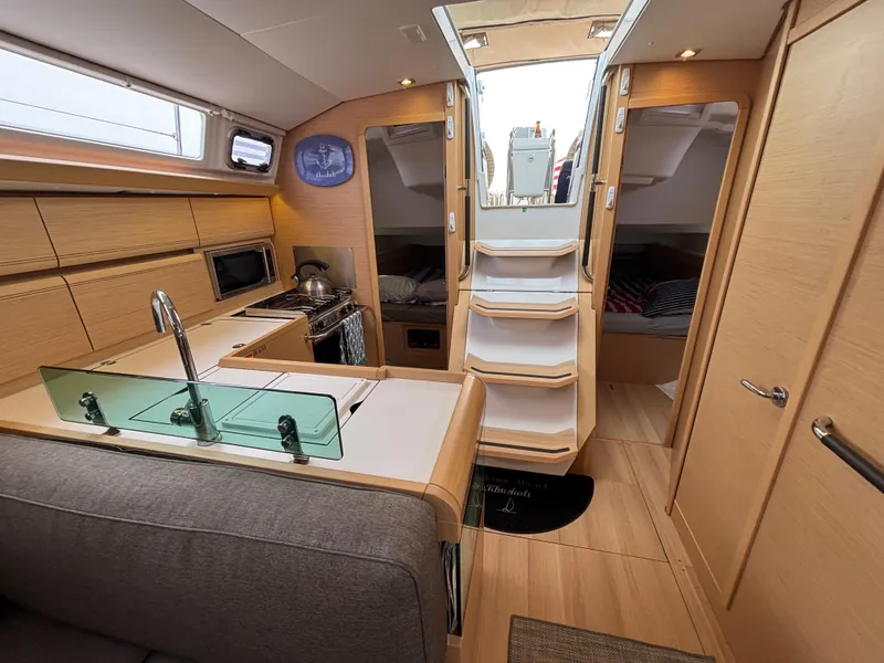 Slide: The Image of Interior of 2019 Jeanneau Sun Odyssey 419 yacht with modern kitchen and cozy seating area. - 14