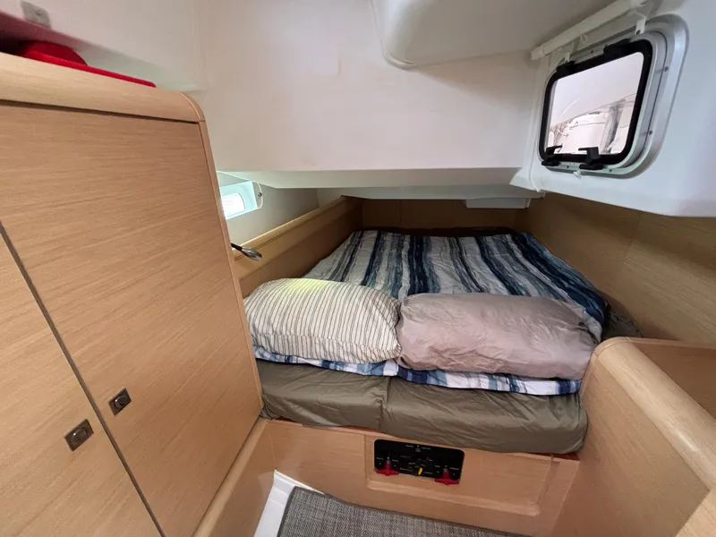 Slide: The Image of Cozy cabin interior of 2019 Jeanneau Sun Odyssey 419 sailboat with striped bedding. - 18