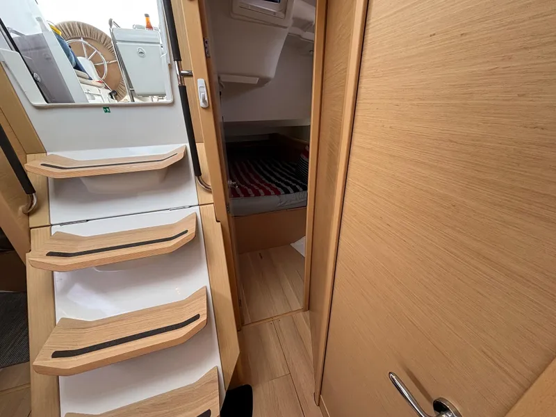 Slide: The Image of Interior of 2019 Jeanneau Sun Odyssey 419 sailboat, featuring wooden stairs and cozy cabin. - 19