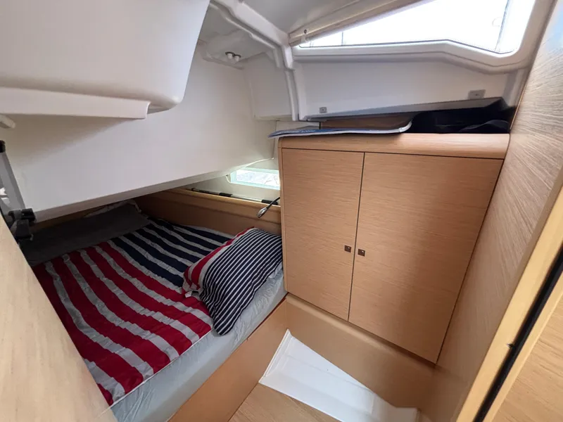 Slide: The Image of Cozy cabin interior of 2019 Jeanneau Sun Odyssey 419 with striped bedding and wooden cabinetry. - 20