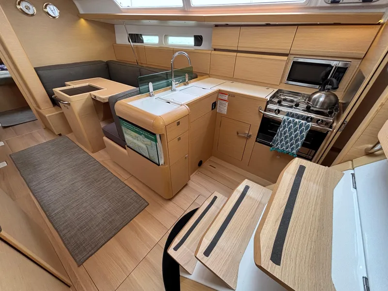 Slide: The Image of Interior of 2019 Jeanneau Sun Odyssey 419 sailboat, featuring modern kitchen and seating area. - 22