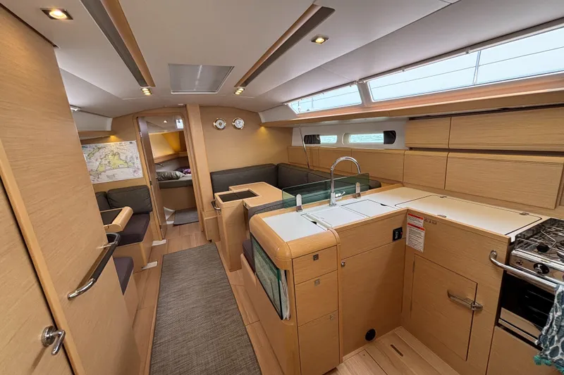 Slide: The Image of 2019 Jeanneau Sun Odyssey 419 interior with modern kitchen and cozy seating area. - 24