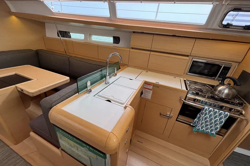Slide: The Image of Interior of 2019 Jeanneau Sun Odyssey 419 yacht, featuring modern kitchen and seating area. - 25