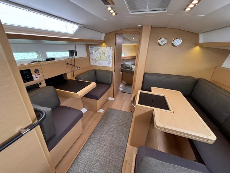 Slide: The Image of Interior of 2019 Jeanneau Sun Odyssey 419 sailboat, featuring modern seating and navigation area. - 26
