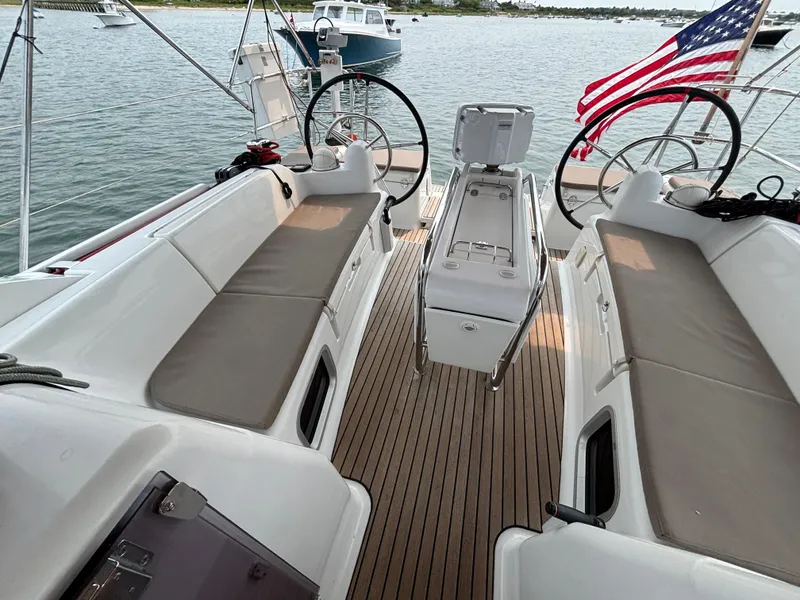 Slide: The Image of 2019 Jeanneau Sun Odyssey 419 sailboat cockpit with dual steering wheels and American flag. - 49
