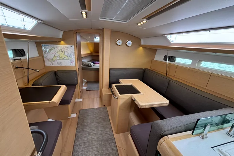 Slide: The Image of Interior of 2019 Jeanneau Sun Odyssey 419 sailboat, featuring modern seating and navigation area. - 5