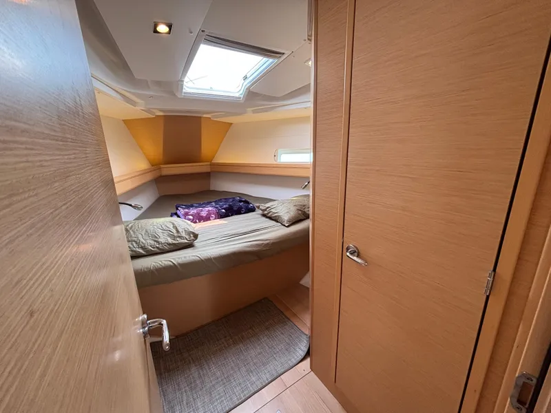 Slide: The Image of Interior cabin of 2019 Jeanneau Sun Odyssey 419 yacht, featuring cozy bedding and natural light. - 8