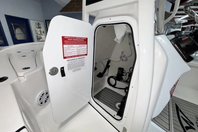Slide: The Image of 2026 Tidewater 2110 Bay Max boat interior with open storage compartment and safety instructions. - 23