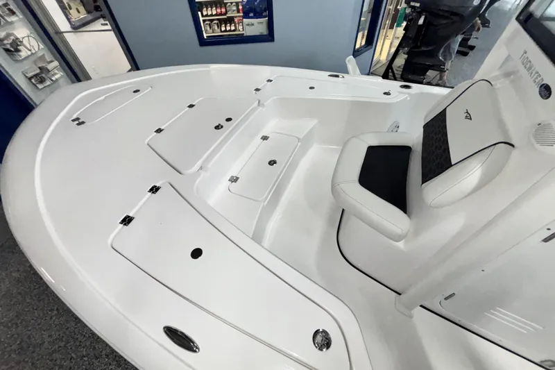 Slide: The Image of 2026 Tidewater 2110 Bay Max boat interior with white seating and storage compartments. - 26