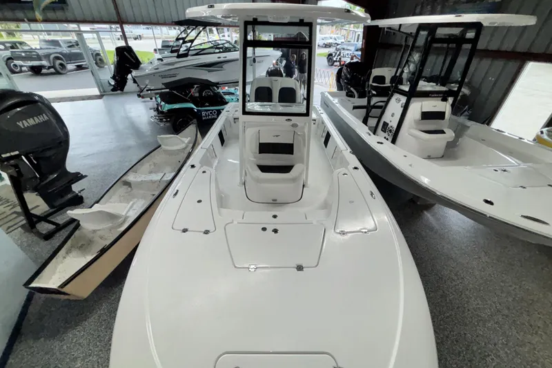 Slide: The Image of 2026 Tidewater 2110 Bay Max boat displayed in a showroom with other boats. - 28
