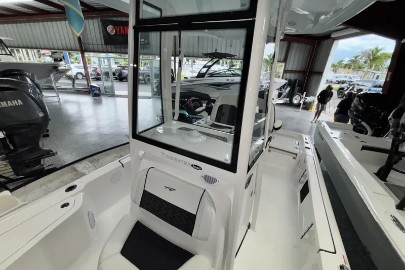 Slide: The Image of 2026 Tidewater 2110 Bay Max boat interior in showroom, featuring seating and console. - 29