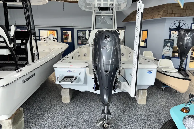 Slide: The Image of 2026 Tidewater 2110 Bay Max boat displayed in showroom with powerful outboard motor. - 4