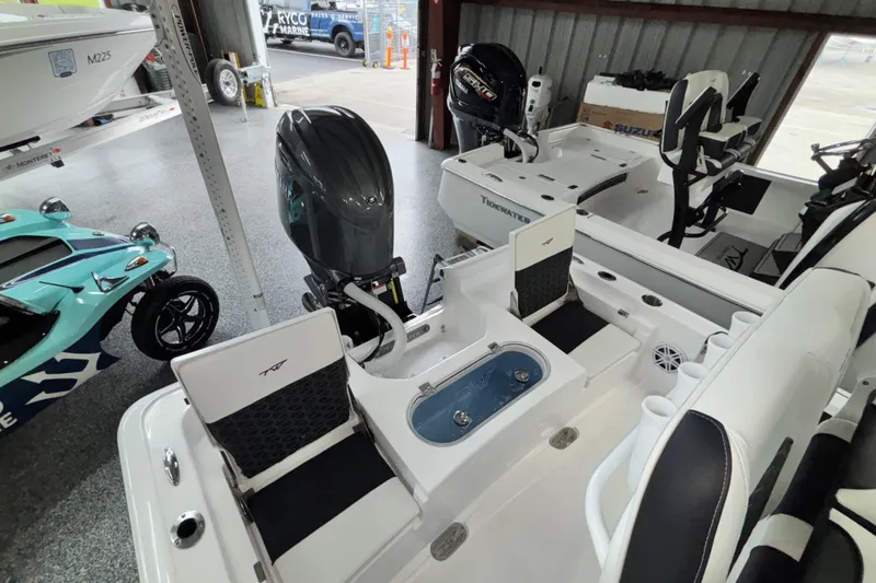 Slide: The Image of 2026 Tidewater 2110 Bay Max boat interior with seating and motor in showroom. - 9