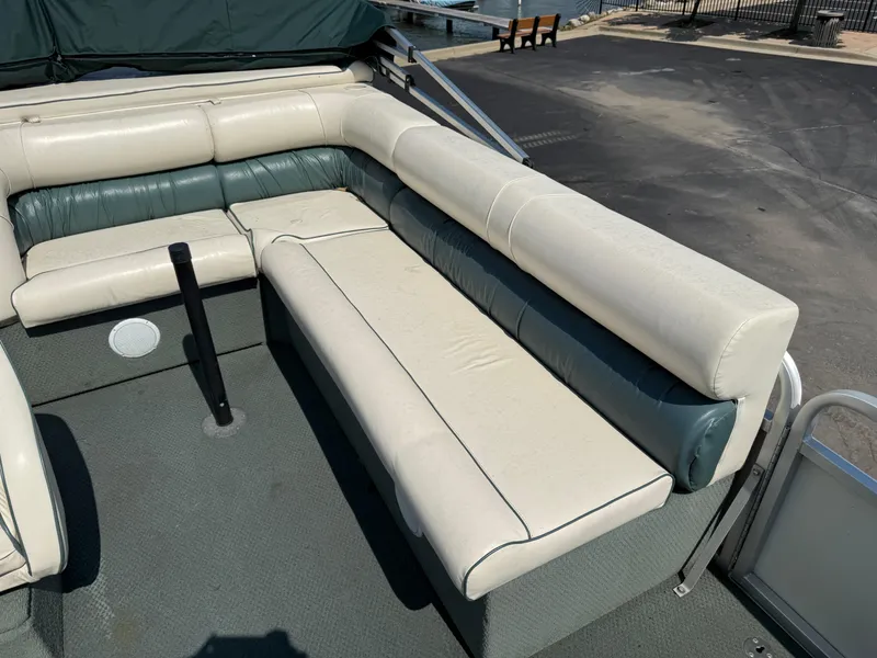 Slide: The Image of Interior seating of a 2000 Playbuoy Yachtsman 21 pontoon boat, featuring cushioned benches. - 11