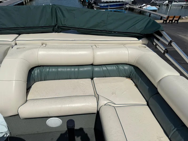 Slide: The Image of Playbuoy Yachtsman 21 boat interior with cushioned seating, docked at a marina. - 12