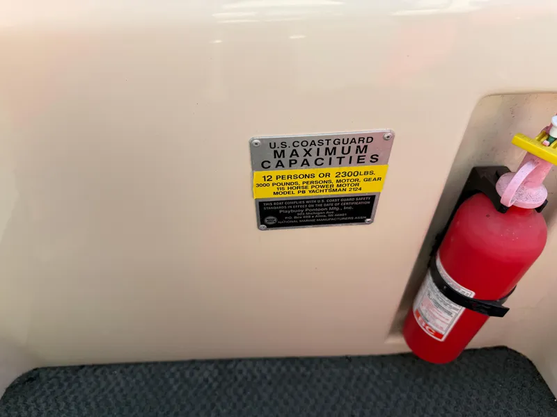 Slide: The Image of U.S. Coast Guard capacity label and fire extinguisher on 2000 Playbuoy Yachtsman 21 boat. - 17