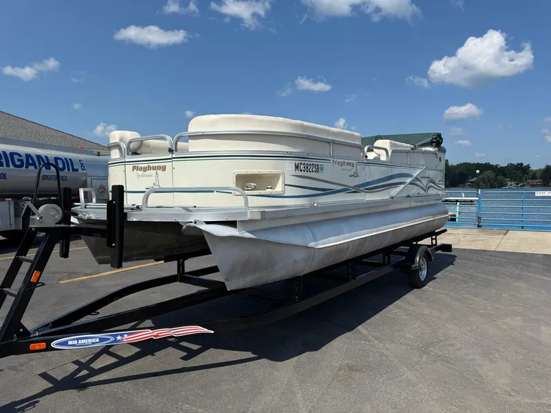 Slide: The Image of Playbuoy Yachtsman 21 pontoon boat on trailer, sunny day, blue sky, 2000 model. - 2