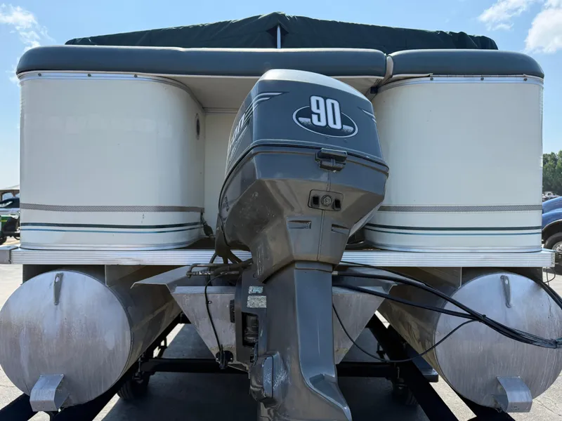 Slide: The Image of 2000 Playbuoy Yachtsman 21 pontoon boat with 90 HP outboard motor, docked under blue sky. - 6
