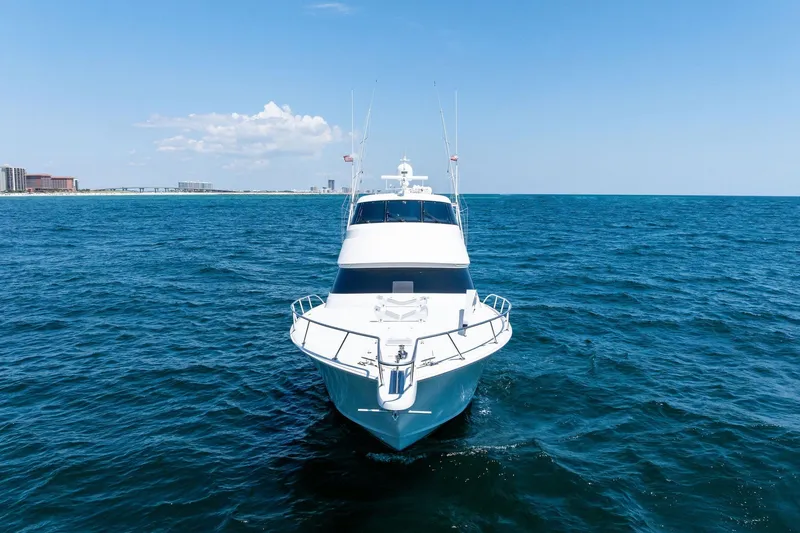 Slide: The Image of 2017 Viking 62 Enclosed Bridge yacht cruising on open sea under clear sky. - 2