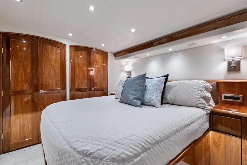 Slide: The Image of Luxurious bedroom interior of 2017 Viking 62 Enclosed Bridge yacht with elegant wood finishes. - 33