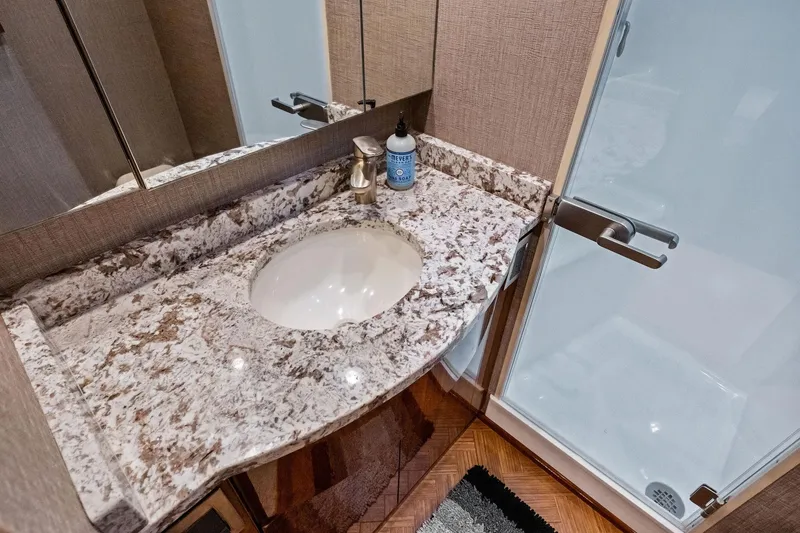 Slide: The Image of Luxurious bathroom in 2017 Viking 62 Enclosed Bridge yacht with granite countertop and modern fixtures. - 37