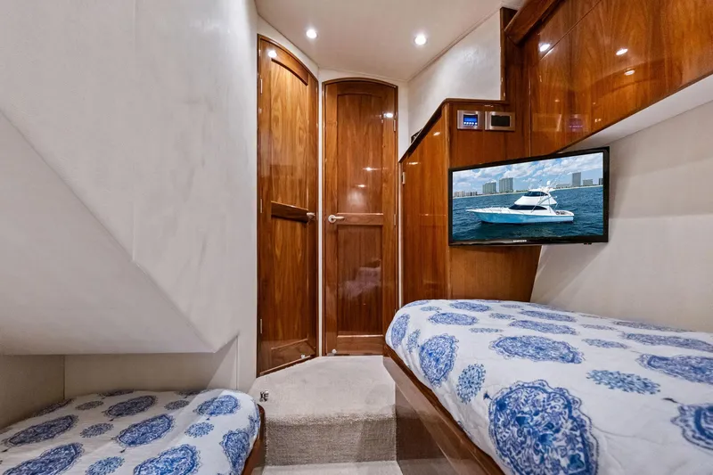 Slide: The Image of Luxurious cabin interior of 2017 Viking 62 Enclosed Bridge yacht with wooden finishes and TV. - 47