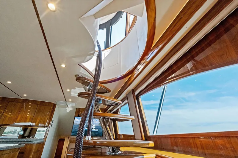 Slide: The Image of Interior view of 2017 Viking 62 Enclosed Bridge yacht with elegant wooden staircase. - 54