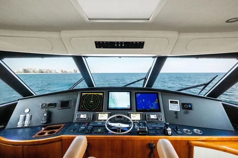 Slide: The Image of Interior view of 2017 Viking 62 Enclosed Bridge yacht's helm with navigation screens. - 55