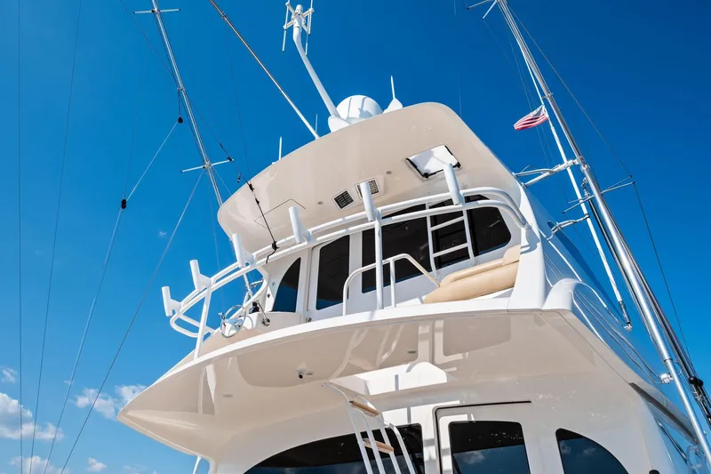 Slide: The Image of 2017 Viking 62 Enclosed Bridge yacht against clear blue sky. - 64