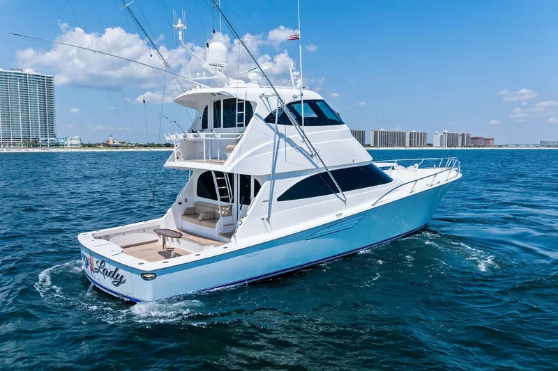 Slide: The Image of 2017 Viking 62 Enclosed Bridge yacht cruising on blue ocean near city skyline. - 7