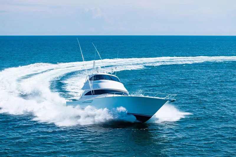 Slide: The Image of 2017 Viking 62 Enclosed Bridge yacht cruising swiftly on open ocean waters. - 9