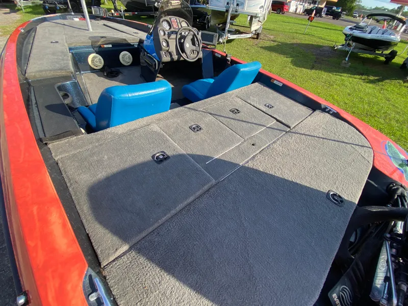 Slide: The Image of 1999 Stratos 283 boat interior with blue seats and control panel, parked on grass. - 5