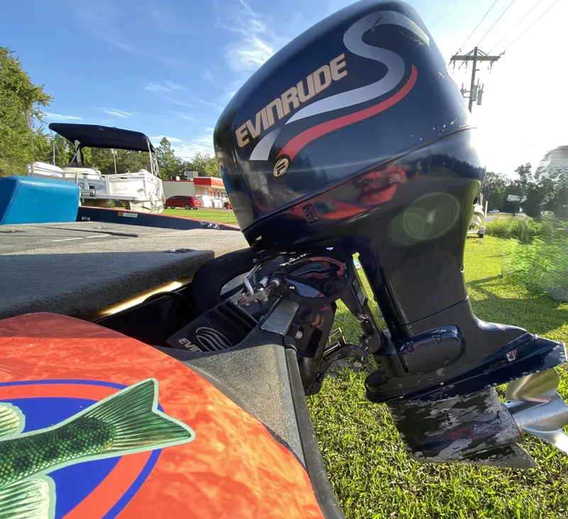 Slide: The Image of Boat with Evinrude motor on a 1999 Stratos 283, sunny outdoor setting. - 7