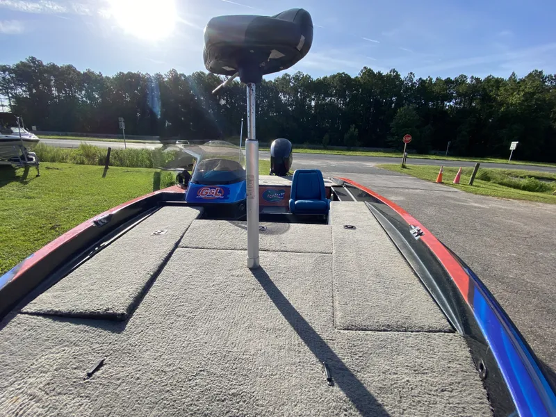 Slide: The Image of 1999 Stratos 283 boat deck with seating, parked near a road and trees. - 8