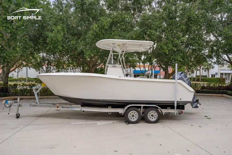 Slide: The Image of 2020 Release 210 RX boat on trailer, parked outdoors with trees in background. - 0